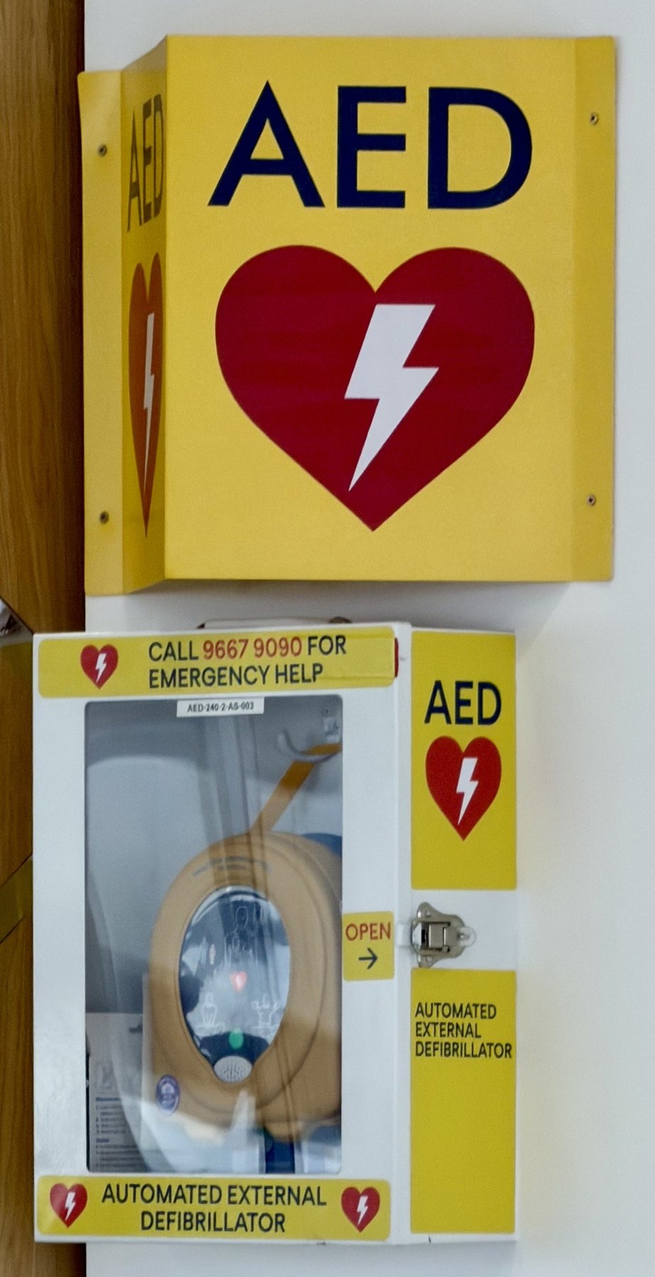AED mounted on a wall in a public-access cabinet